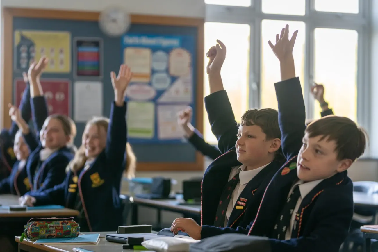 Pupils raising hands in classroom