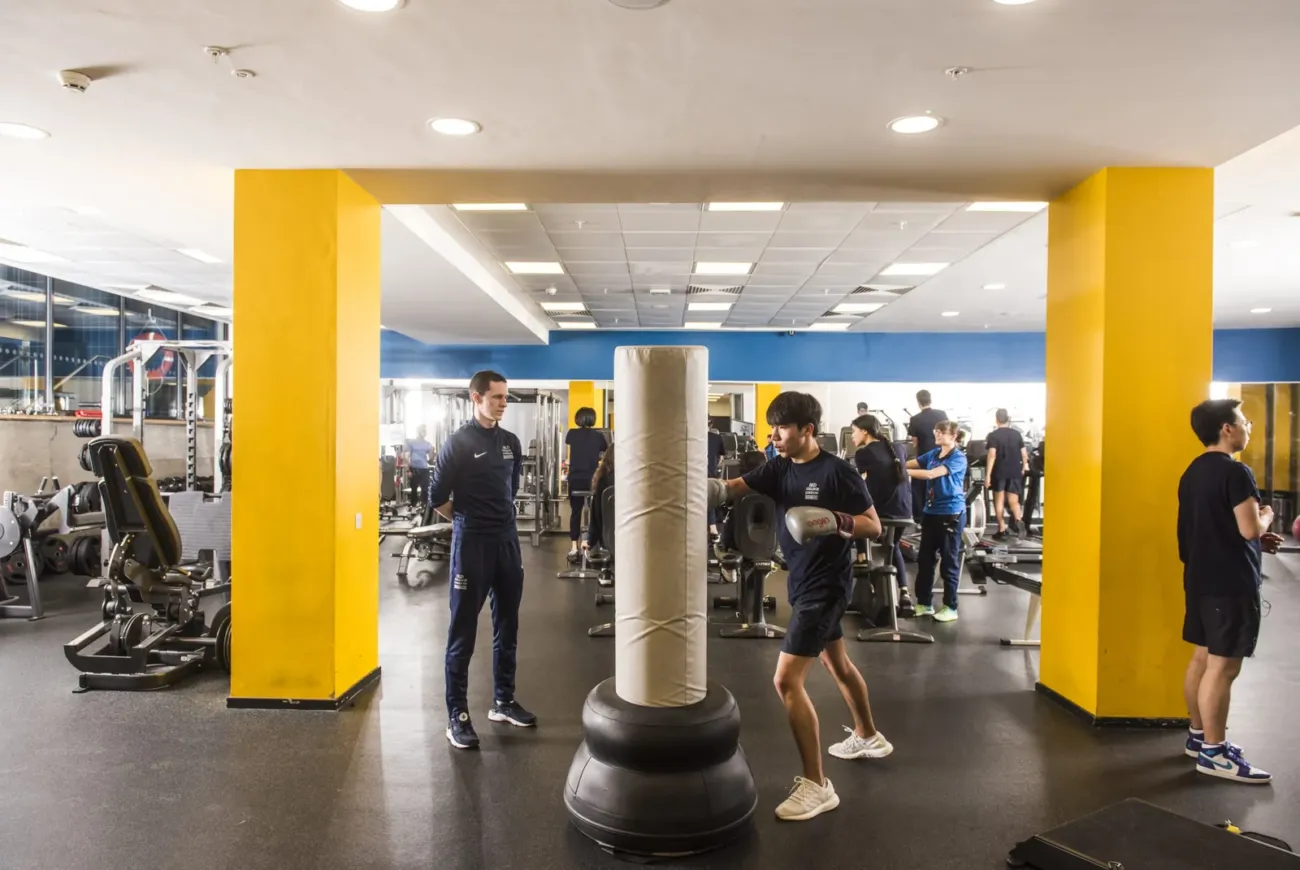Student boxing in well-equipped college gym