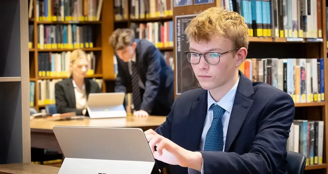 Student studying on laptop in library