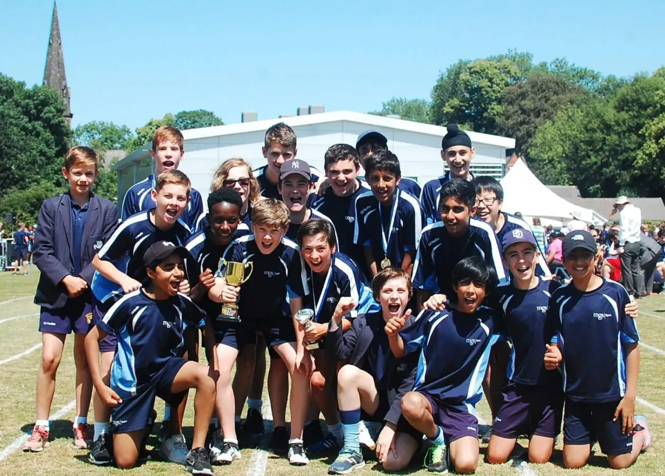 Boys celebrate winning sports trophy outdoors