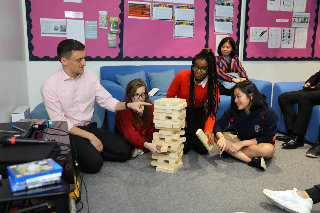 Students and teacher playing giant Jenga